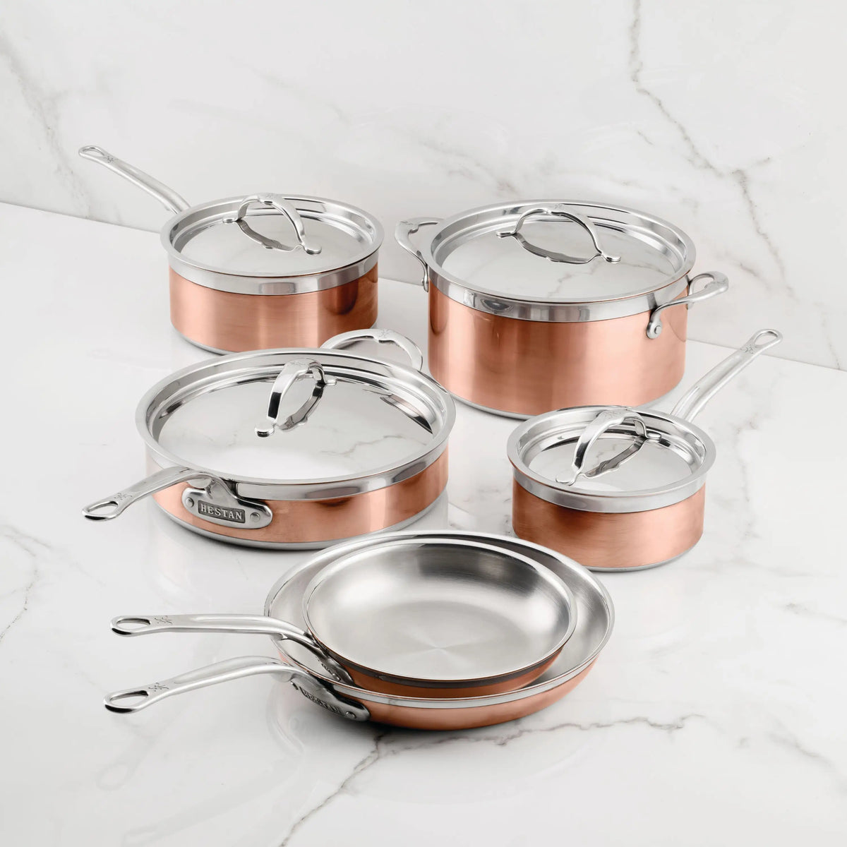 The CopperBond Copper Induction Ultimate Set, 10-Piece, features premium copper core pots and pans, beautifully arranged on a white marble surface.