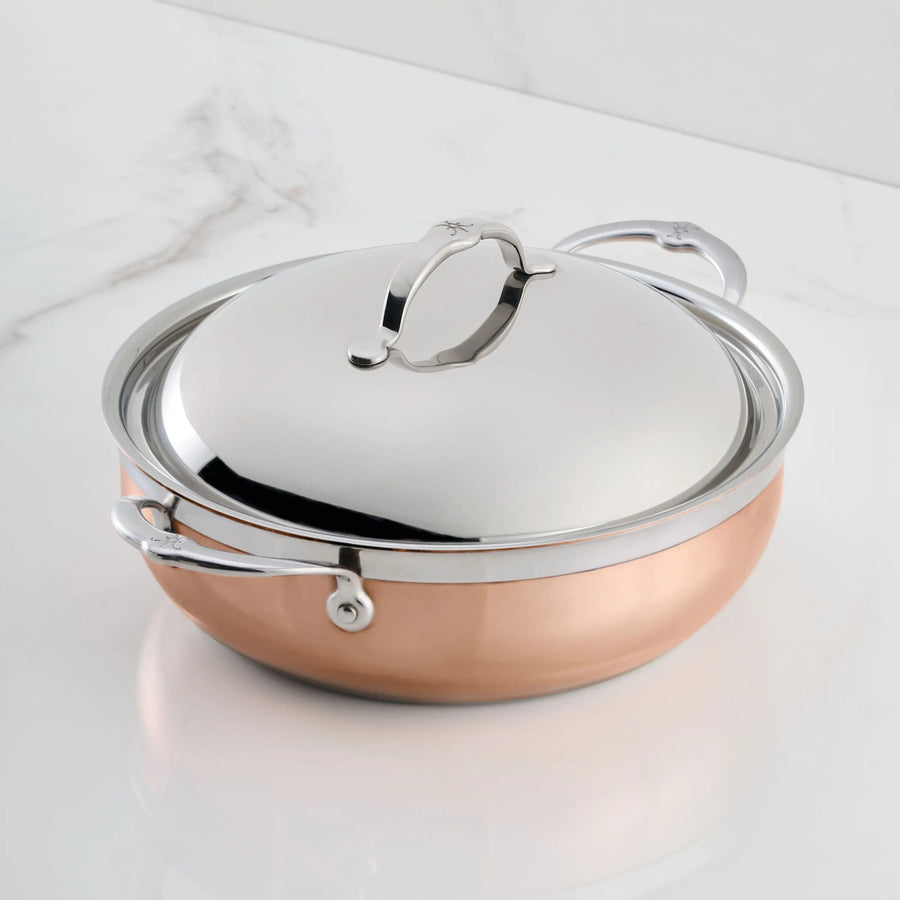 The CopperBond Copper Induction Dutch Oven, 5-Quart, with two handles and matching lid, is shown on a white marble surface, combining induction compatibility with timeless style.