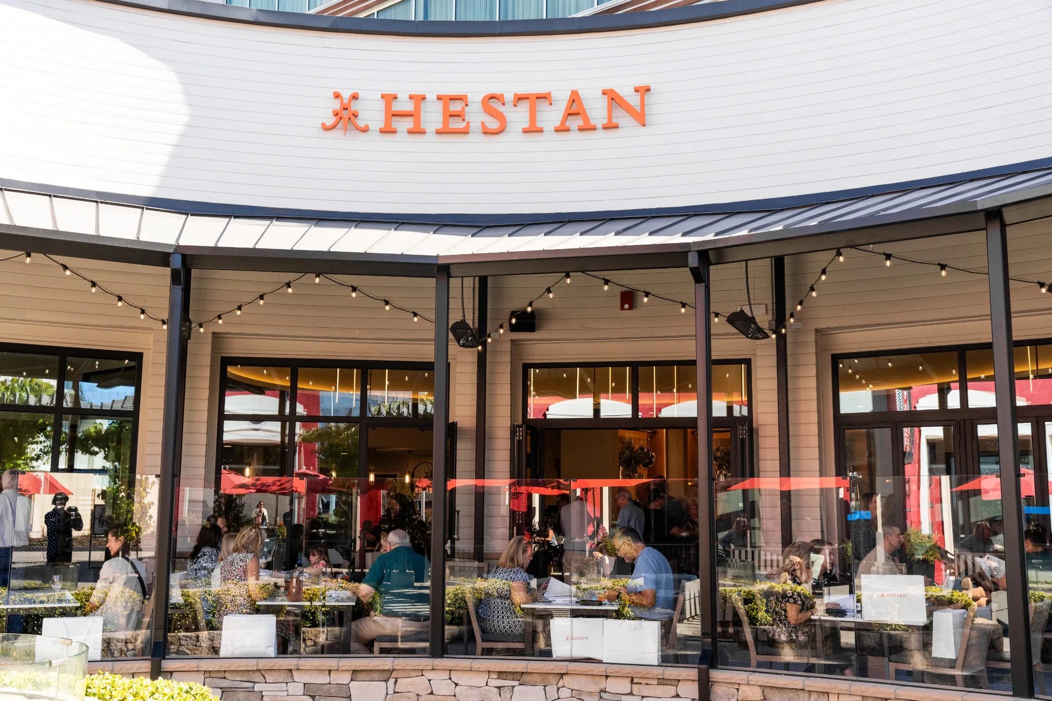 Hestan restaurant exterior with people dining inside
