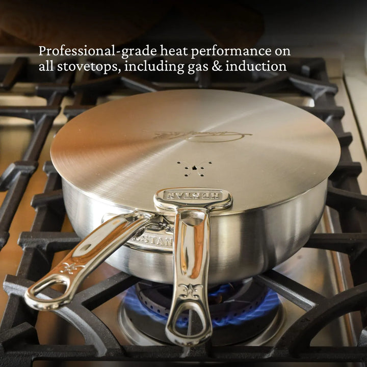 A Thomas Keller Commercial Clad Stainless Steel 11-Piece Cookware Set saucepan with lid sits on a gas burner. Text: Tri-ply construction delivers pro-level heat on all stovetops, including gas and induction.