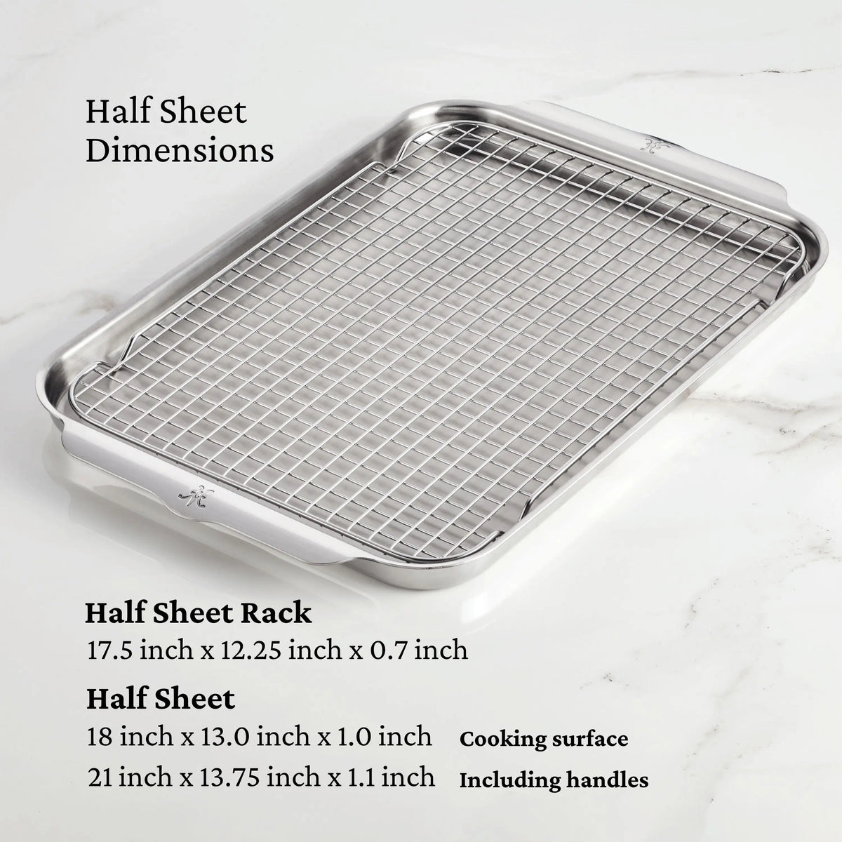 A Thomas Keller Commercial Clad 29-piece stainless steel cookware set is displayed on white marble. Text provides dimensions for the pans and lids, detailing both cooking surface and handle measurements.