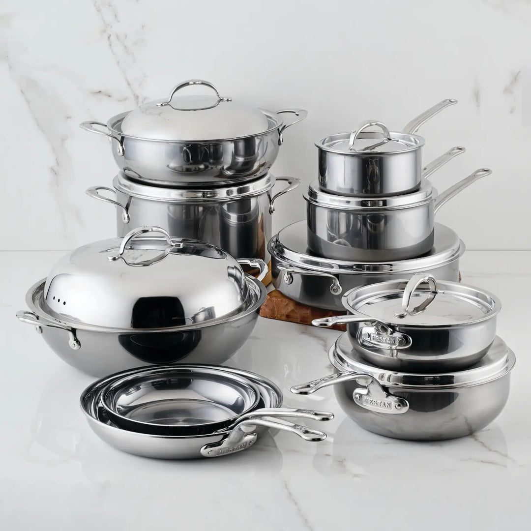 The NanoBond 18-Piece Limited Edition Titanium Cookware Set, featuring various pots, pans, and lids for versatile cooking, is displayed on a white marble surface.