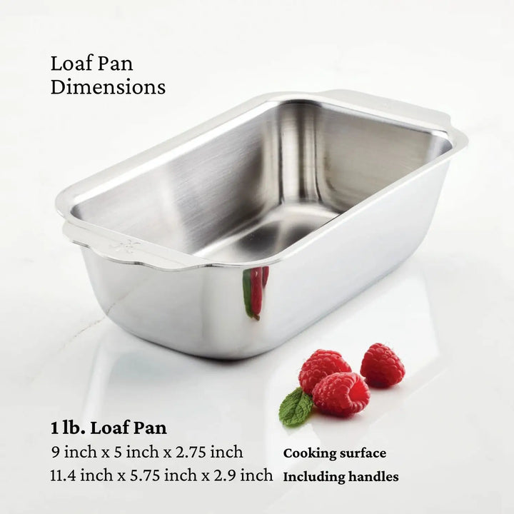 A stainless steel loaf pan from the Hestan Provisions OvenBond Tri-Ply 3-Piece Baking Set is on a white surface with three raspberries. Text shows Loaf Pan Dimensions with sizes of 9 x 5 x 2.75 inches and 11.4 x 5.75 x 2.9 inches (handles included)—warp-resistant for reliable baking every time.