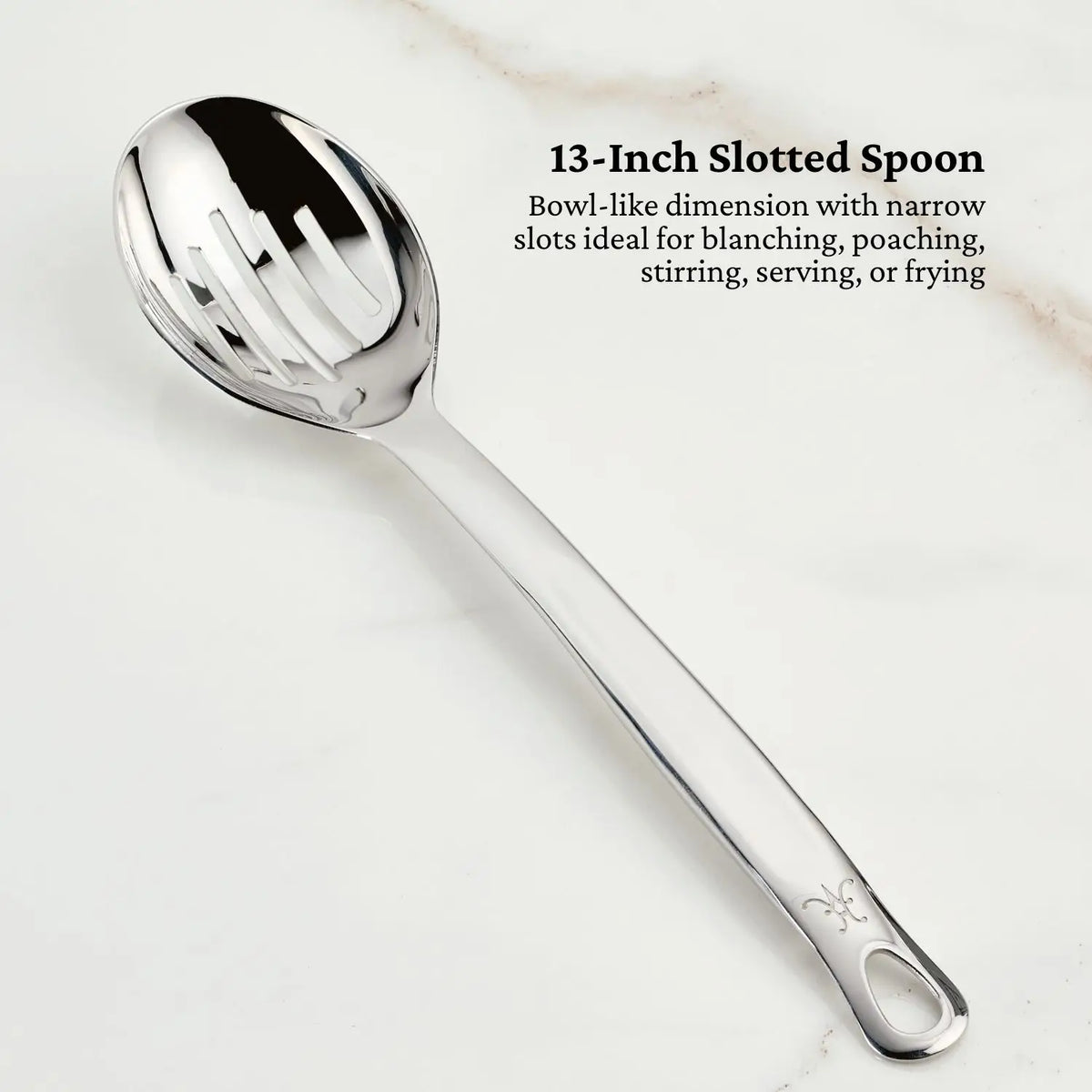 A 13-inch reflective, tri-ply stainless steel slotted spoon from Hestan Provisions OvenBond Tri-ply Epicurean Stainless Steel 21-Piece Set lies on a marble surface. Ideal for blanching, poaching, stirring, serving, or frying. Black text describes its features in the top right corner.