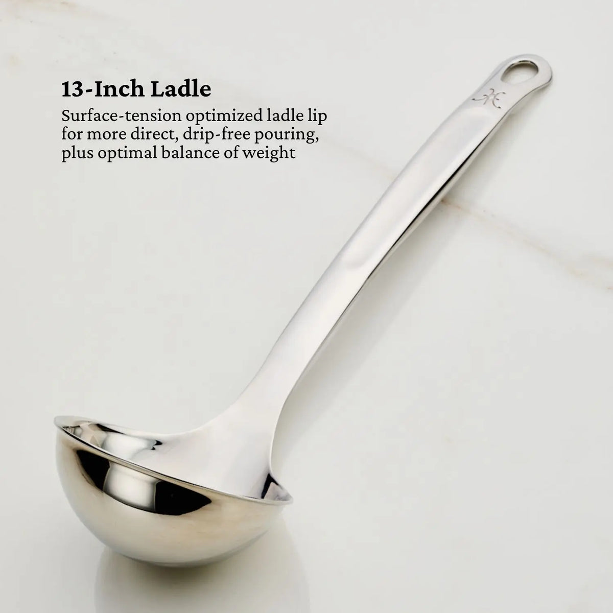 Displayed on a light marble surface is the Hestan Provisions OvenBond Tri-ply 13-inch stainless steel ladle from the Epicurean 21-Piece Set. It has a curved lip for drip-free pouring, with text highlighting its optimal balance and expertly crafted durability typical of high-quality bakeware.