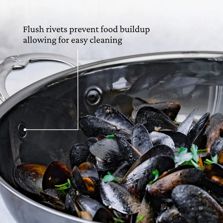 Cooked mussels garnished with herbs in a NanoBond 10-piece Limited Edition Winter Titanium Cookware Set. The stainless steel pot with molecular titanium and flush rivets prevents food buildup for easy cleaning.