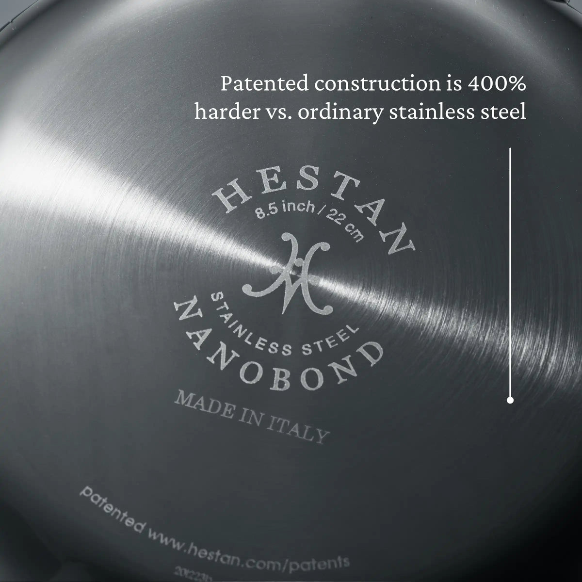 Close-up of the bottom of a NanoBond Titanium Skillet, showing the brand name, product size, and “Patented construction with molecular titanium is 400% harder vs. ordinary stainless steel” next to a vertical line.