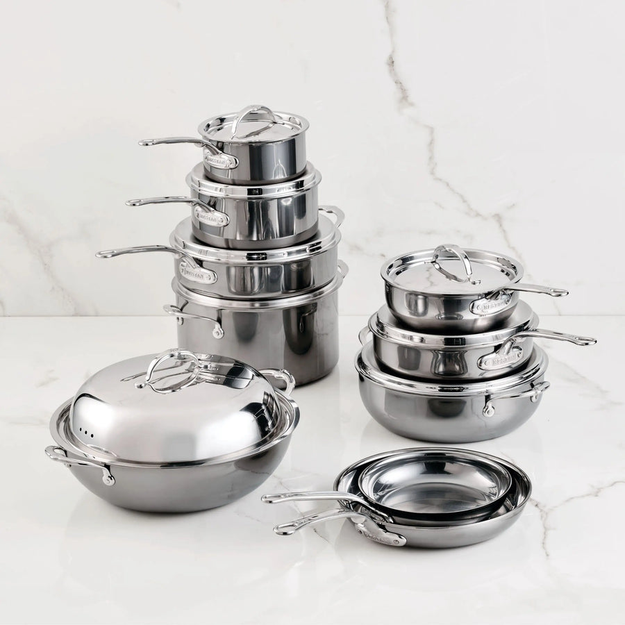The 18-Piece Titanium Cookware Set with Dutch Oven by NanoBond, featuring pots, pans, and lids, is arranged in stacked and nested groups by size on a white marble surface with a light marble background.