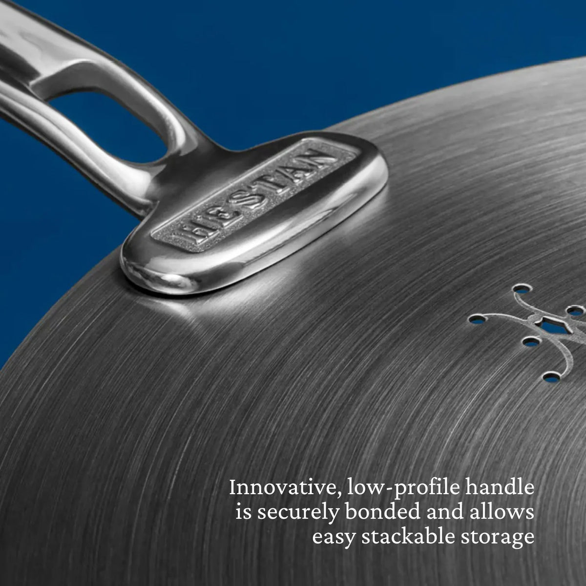 Close-up of a Thomas Keller Commercial Clad Stainless Steel 11-Piece Cookware Set pan, featuring a secure, innovative low-profile handle that&