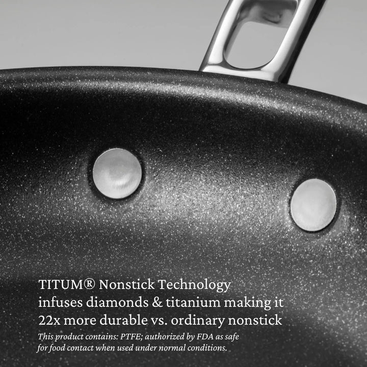 Close-up of a nonstick frying pan with two metal rivets, featuring TITUM® Nonstick Technology—22× more durable than ordinary pans. Part of the Thomas Keller Commercial Clad Stainless Steel 11-Piece Cookware Set.